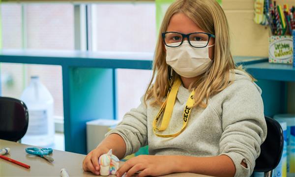 Girl works on food model made of clay